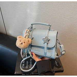 Petit sac carré en cuir grainé bleu clair avec rivets en étoile et pendentif ours