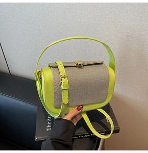 Detail of trendy neon green pillow bag with woven flap and gold shell-shaped twist lock