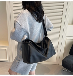 Detail of black large capacity crossbody bag featuring premium lychee grain leather texture