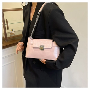 Sac à bandoulière en cuir verni rose avec chaîne argentée et texture plissée sur mannequin