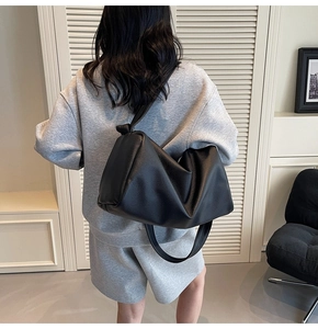 Rear view of a black pebbled leather hobo bag worn over the shoulder for a chic look