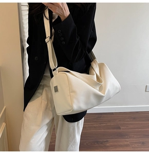 Close-up of cream Boston bag with lychee texture and adjustable wide shoulder strap