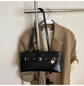 Glossy black patent leather underarm bag with silver heart charm and belt detail