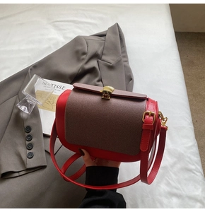 Detail of red and dark brown patchwork pillow bag with gold scallop buckle and strap