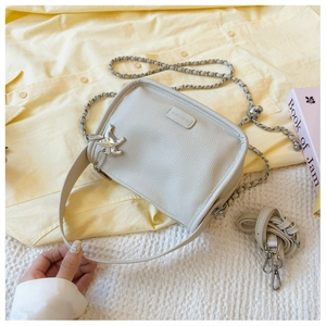 Detail of creamy white pebble leather square bag with silver chain and sheep charm