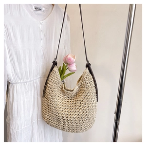 Détail du sac seau hobo en paille avec lanières marron foncé et texture tressée