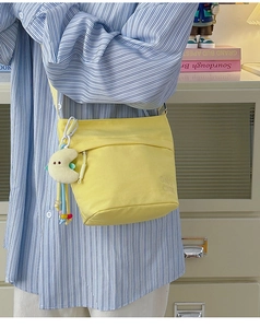 Dettaglio borsa tote in nylon giallo con ciondolo a luna in peluche e perline