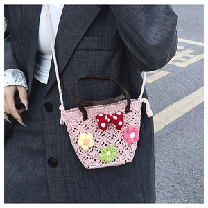 Close-up of pink woven floral bag with polka dot bow and 3D crochet flower details