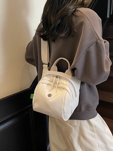 Minimalist white canvas mini shell bag shown from back view on a model