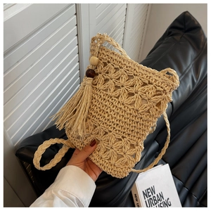 Détail du sac en paille ajouré avec des glands et des perles en bois vintage