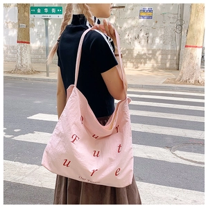 Λεπτομέρεια ροζ νάιλον τσάντας tote με κόκκινη στάμπα Future φορεμένη σε αστικό στυλ