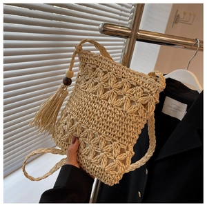 Détail de tissage en paille ajouré avec des pompons et des perles en bois