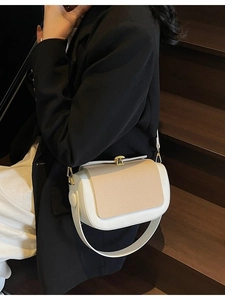 Chic two-tone pillow bag in white and beige with gold hardware on a stylish model