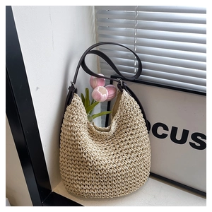 Détail de la texture alvéolée tissée main du sac seau en paille avec bandoulière en cuir