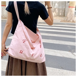 Ροζ νάιλον τσάντα ώμου σε street style λήψη φορεμένη από μοντέλο στο δρόμο