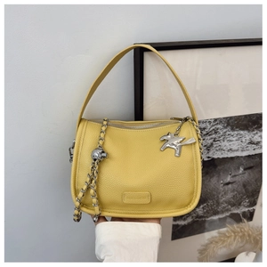 Detail of yellow lychee texture leather bag with silver Pegasus charm and logo