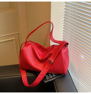 Close-up of red lychee grain leather texture and polished silver metal zipper detail
