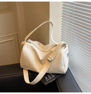 Detail of off-white lychee texture leather bag with adjustable strap and silver zipper