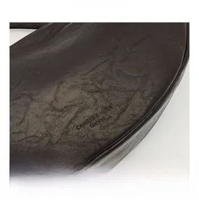 Detail shot of black oil-wax textured leather crossbody bag with brand embossing
