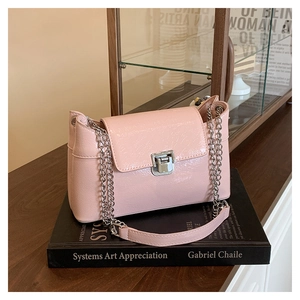 Détail du sac en similicuir rose brillant avec chaîne argentée et fermoir métallique