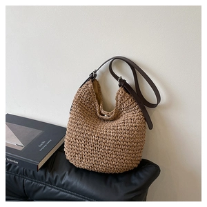 Gros plan détaillé du sac hobo en paille tressée montrant la texture et la bandoulière