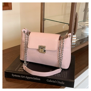 Détail de la texture cuir rose craquelé avec chaîne argentée et fermoir métallique
