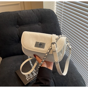 Detailed view of white quilted faux leather mini bag with silver chain and twist-lock