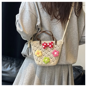 Detailed look at handwoven bucket bag with 3D floral accents and polka dot bow detail