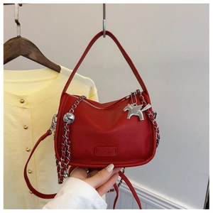 Detail view of red lychee leather small square bag with silver chain and Pegasus charm