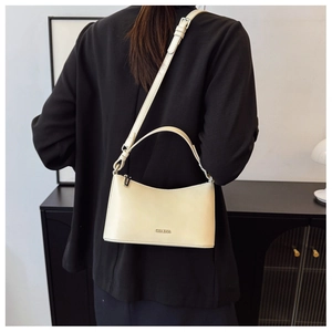 Detail of CHERA cream minimalist shoulder bag on black blazer with adjustable strap