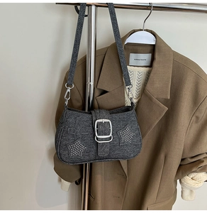 Detail of dark grey denim shoulder bag with silver star and cross rhinestone buckle