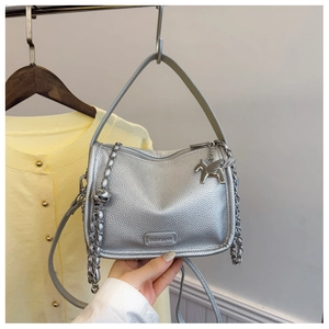 Close-up of silver textured handbag featuring metal chain decor and a Pegasus charm detail