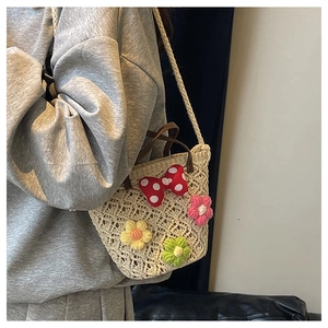 Detail of hand-woven crochet bucket bag featuring colorful 3D flowers and polka dot bow