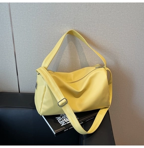 Detail of bright yellow lychee texture leather bag with silver metal decor and dual straps