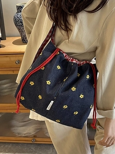 Large capacity denim shoulder bag with floral embroidery and red drawstring bucket design