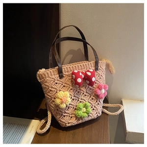 Close-up of handmade hollow woven bucket bag with 3D crochet flowers and bow detail