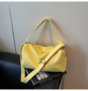 Detail of yellow lychee grain leather boston bag with silver hardware and adjustable strap
