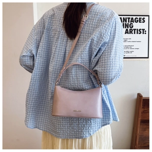Detail of light purple leather crossbody dumpling bag with adjustable shoulder strap