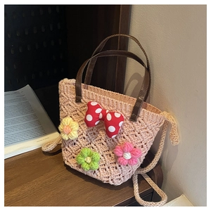 Detail of pink hollow crochet bucket bag with red polka dot bow and leather handles