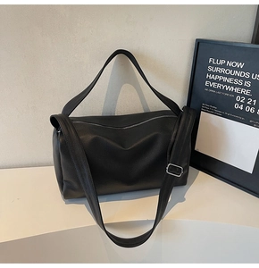 Close-up of black lychee grain leather texture and silver hardware on large tote bag