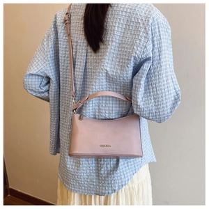 Detail view of lilac leather dumpling bag with silver logo and adjustable shoulder strap