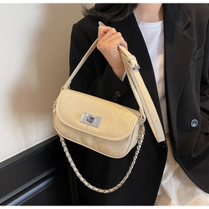 Detail showing creamy white quilted leather bag with silver twist lock and dual straps