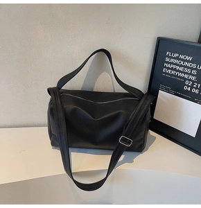 Detail of black lychee grain leather handbag with adjustable silver buckle shoulder strap