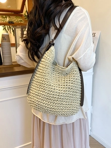 Sac seau en paille tressé avec bandoulière en cuir dans un cadre de café chic