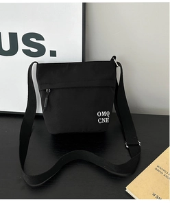 Dettaglio borsa a secchiello in nylon nero con scritta OMQ CNH e fibbia in metallo argento