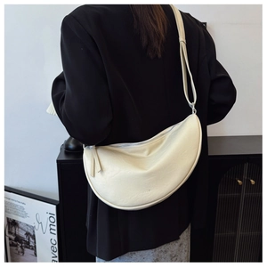 Close-up of a cream white crescent bag showing its smooth texture and logo detail