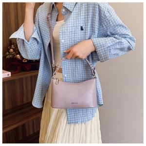 Detail of light purple leather shoulder bag with CNERA logo on blue plaid shirt outfit