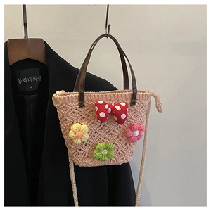 Detail of pink hand-woven crochet bucket bag with 3D floral accents and a bow knot