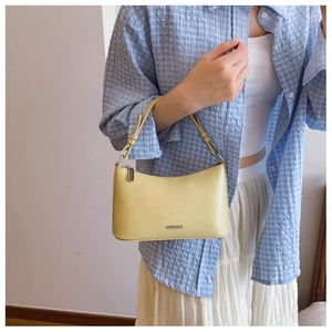 Close-up of a yellow dumpling bag with G&HEKA metal logo and knotted strap detail