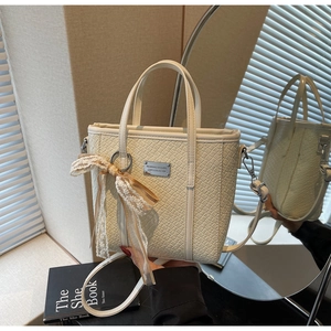 Dettaglio borsa tessuta crema con fiocco in pizzo e placca logo argento in stile elegante